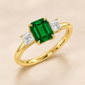 9ct yellow gold lab-grown emerald and diamond three-stone ring, angled view