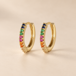 Pair of 14ct gold-plated sterling silver multicoloured CZ hoop earrings on a warm beige background