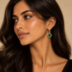 Khush wearing green gold-plated clover hoop earrings with a clear CZ-set border