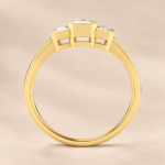 Side view of 9ct yellow gold three-stone emerald-cut lab-grown diamond ring with rub-over settings